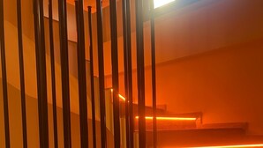 A staircase with warm lighting and metal railings. - Ege Vadi Otel (Ayvalik)