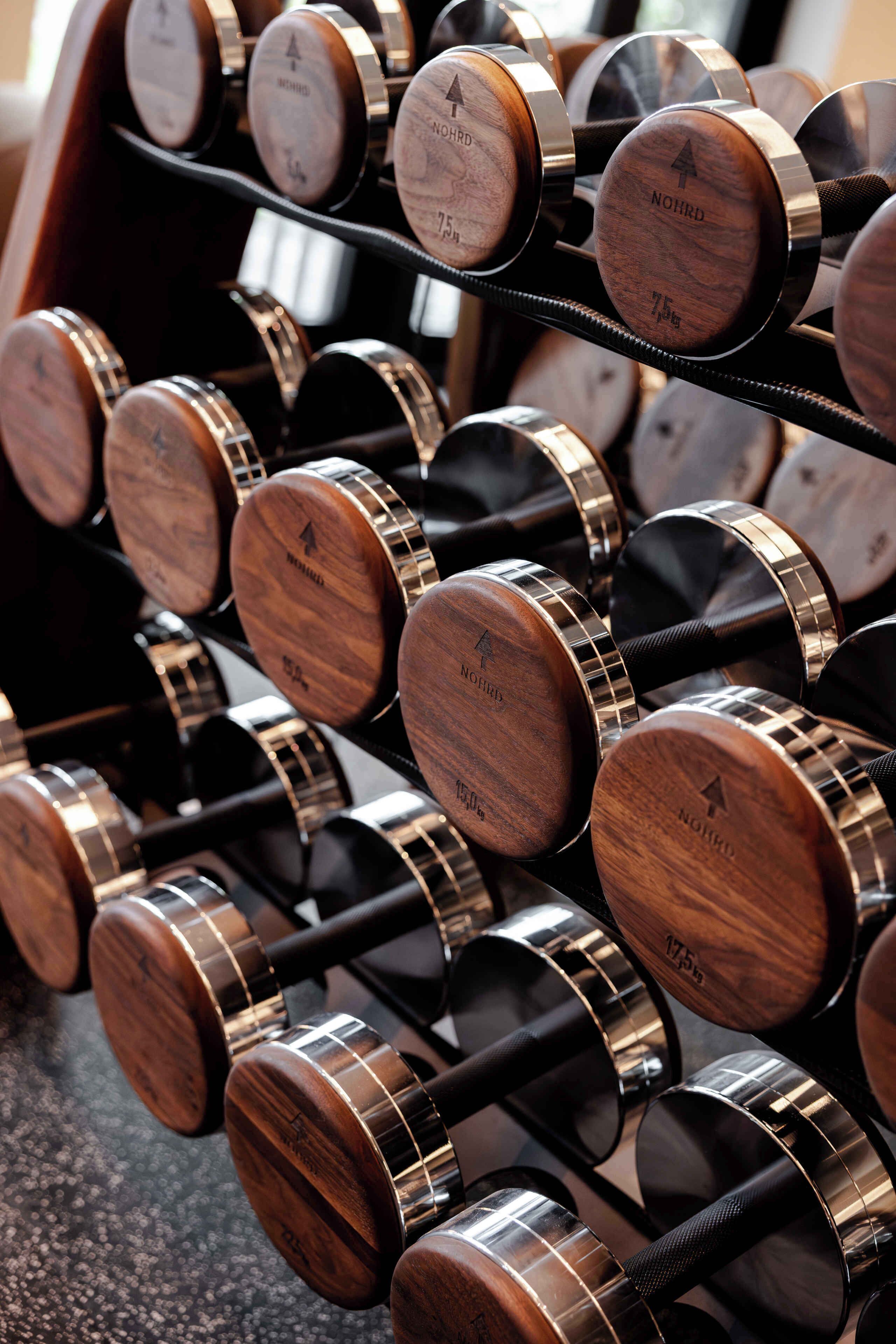 Un estante con mancuernas de madera y marcas de peso.