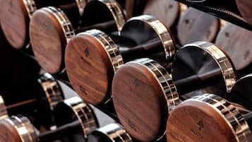 Un estante con mancuernas de madera y marcas de peso.