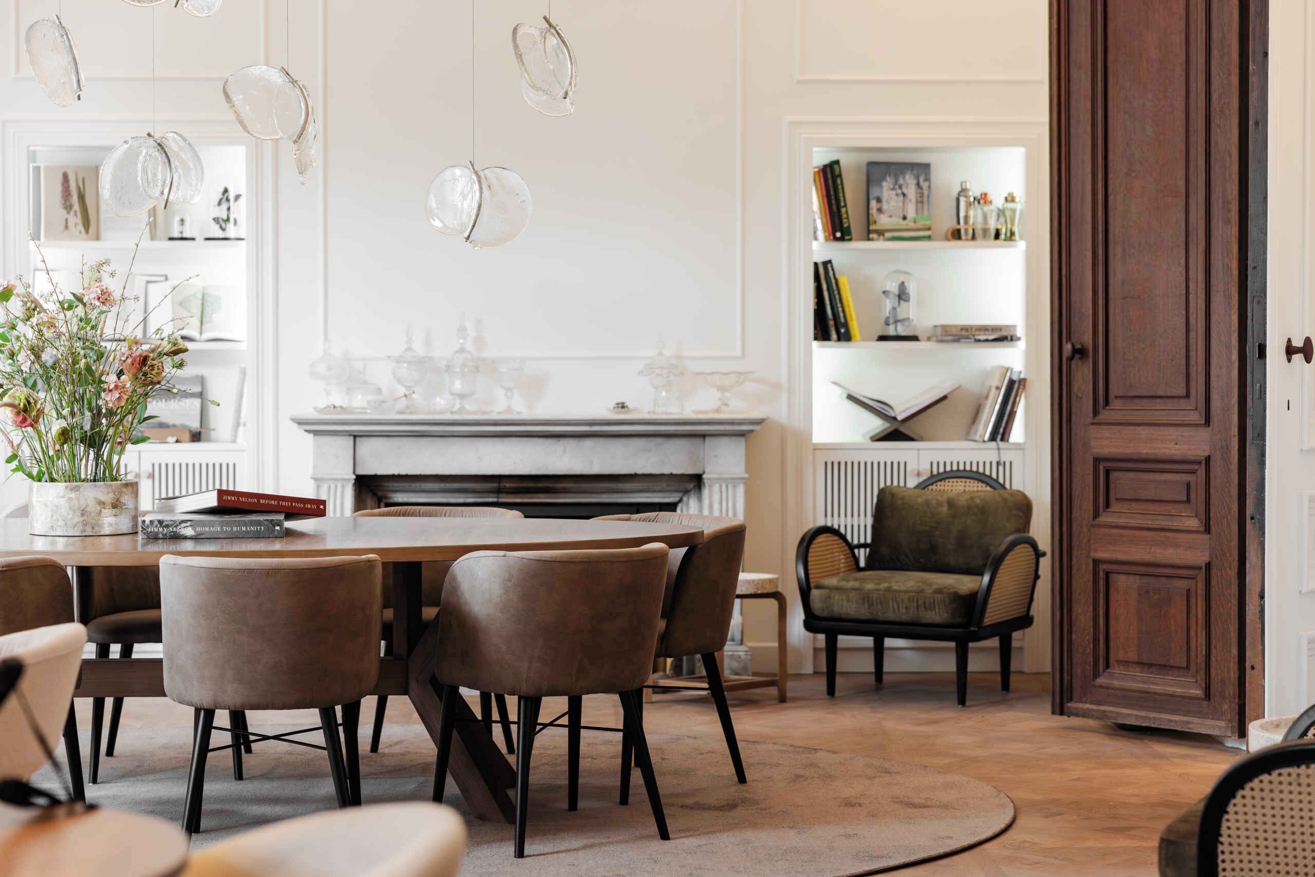 A dining area with a fireplace, a bookshelf, and a door.
