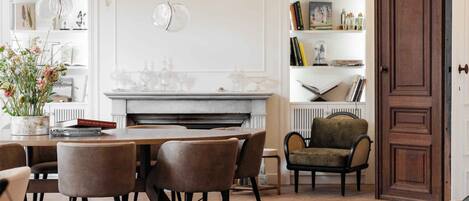 Un comedor con chimenea, una estantería y una puerta.