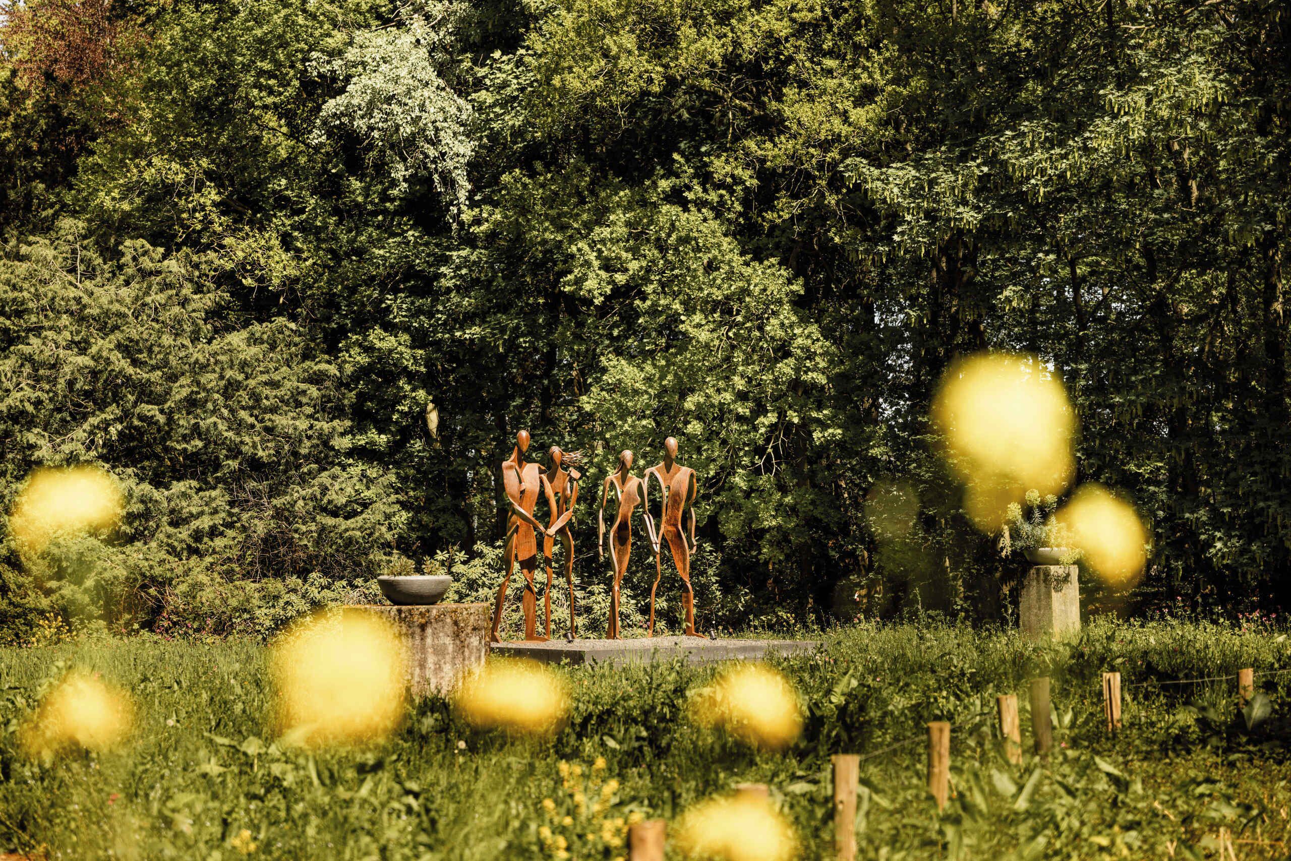 Un jardín con estatuas y un estanque.