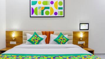 Una habitación de hotel con una cama, dos mesitas de noche, una obra de arte colgada en la pared y un cuadro enmarcado.