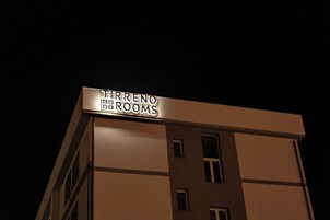 Un edificio con un letrero que dice "TIRRENO ROOMS".