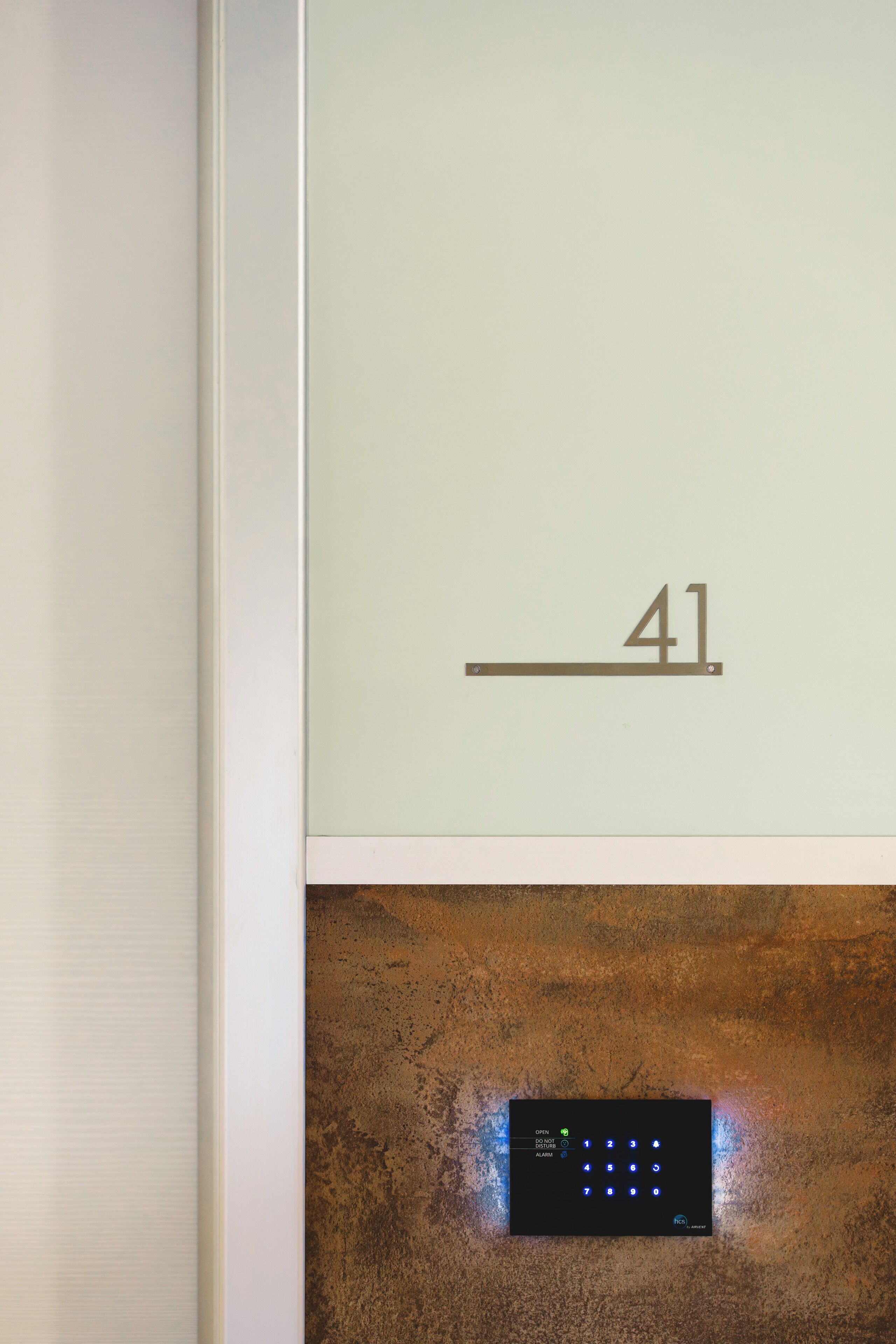 Un muro con il numero "41" e un pannello di controllo digitale sottostante.