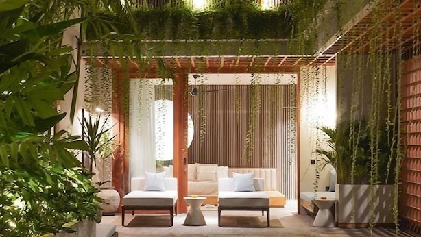 An indoor pool area with two lounge chairs, a small table, and a seating area with cushions. - Vinaka Villa By Betterplace (Canggu)