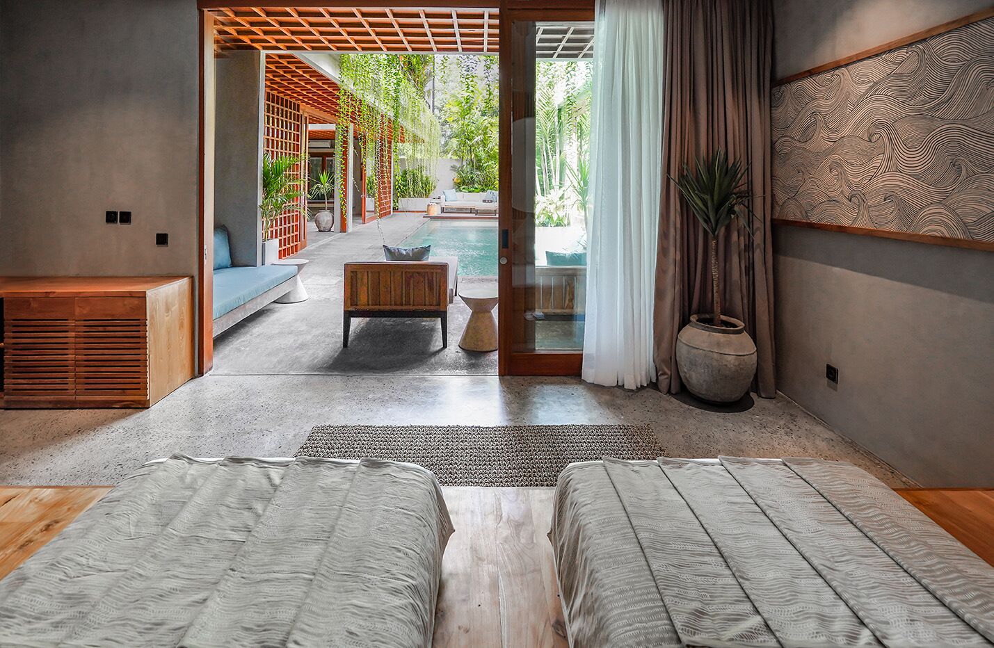 Un dormitorio moderno con una cama grande, una mesita y vistas a una piscina y jardín.