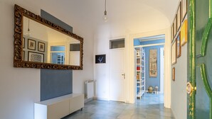 A hallway with a large mirror, a white console, and a green door. - Casa Garibaldi in Piazza by Wonderful Italy (Palermo)
