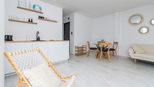 Un espacio habitable moderno y minimalista con cocina, comedor y zona de estar.