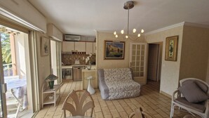 A compact living space with a kitchenette, a dining area with a table and chairs, a sofa, and a chair. - STUDIO + SLEEPING AREA CLOSE TO SHOPS AND BEACHES (Sainte-Maxime)