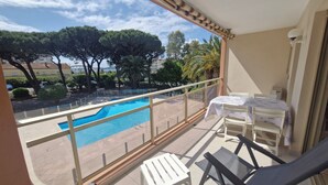 A balcony with a pool, a table with a bowl, and a chair. - STUDIO + SLEEPING AREA CLOSE TO SHOPS AND BEACHES (Sainte-Maxime)