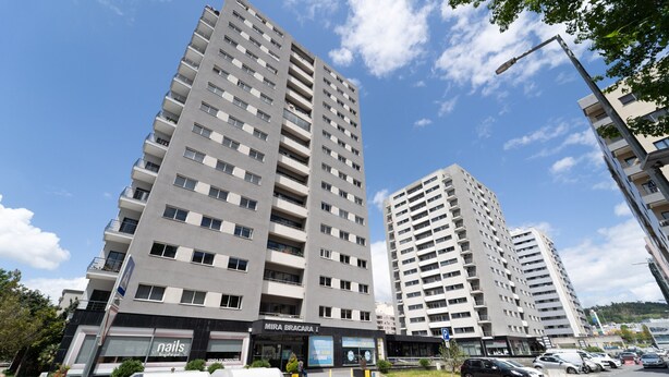 Un moderno edificio de gran altura con varios balcones y una fachada con un cartel que dice 'MIRA BRACARIA'.