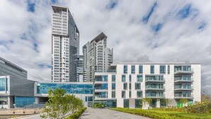 Een modern gebouw met meerdere verdiepingen, grote ramen en een combinatie van balkons en terrassen.