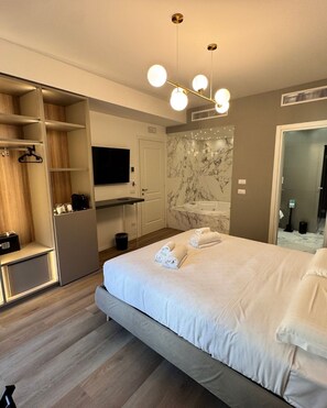 Luxe tweepersoonskamer | Badkamer | Een aparte badkuip en douche, een haardroger, handdoeken, zeep