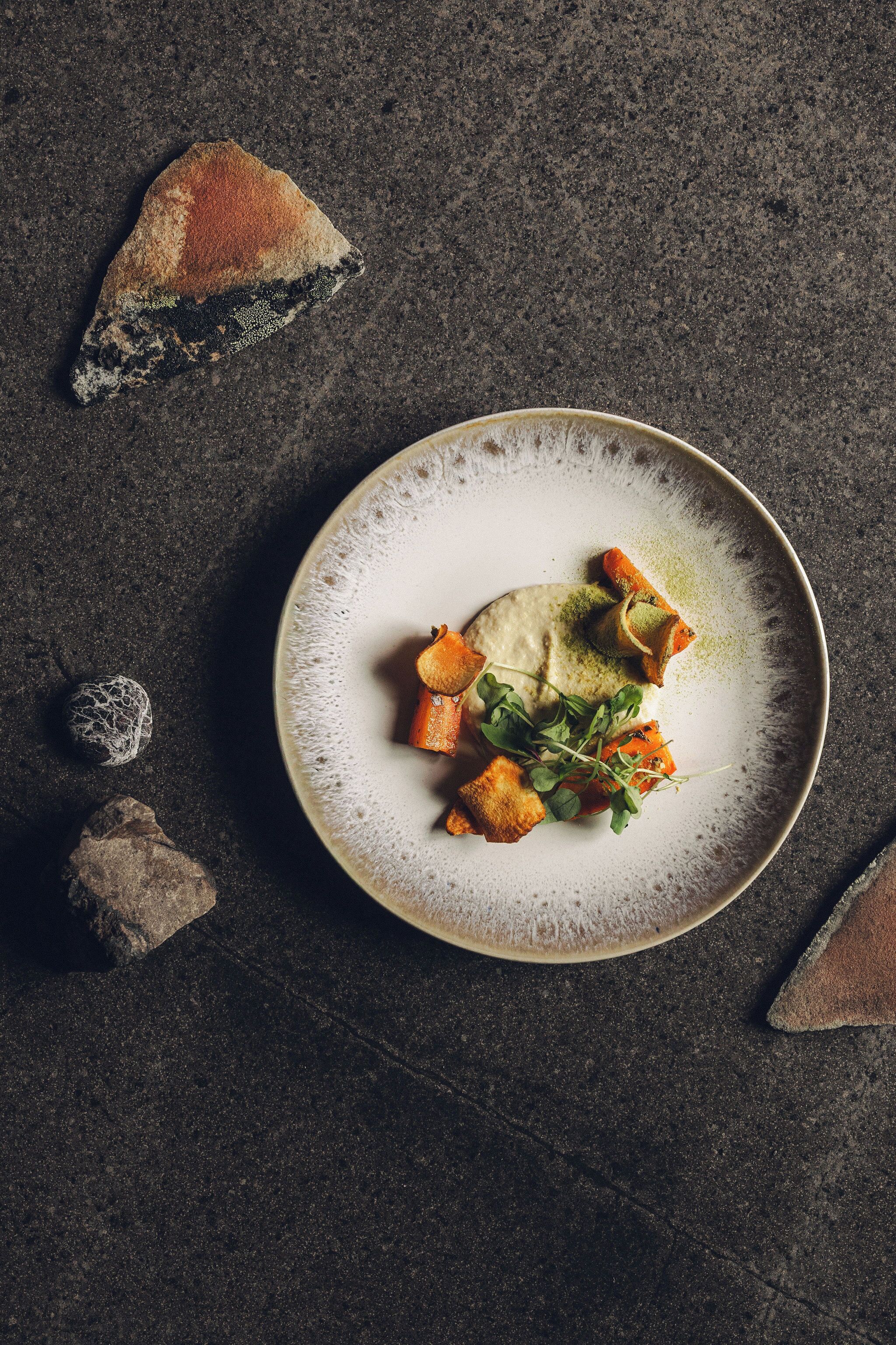 A plate of food on a dark surface with a textured background.