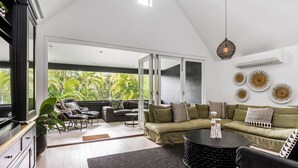 A modern living room with a large window, a sofa set, a coffee table, and decorative wall art.