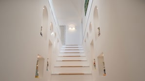 Un interior moderno con una escalera central, paredes blancas y una decoración minimalista.