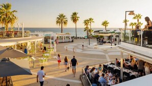 A beachfront restaurant with outdoor seating, palm trees, and a view of the ocean. - 2 bed renovated apartment in vale do lobo Algarve (Loulé)