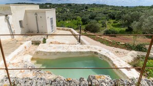 A rooftop pool with a stone edge and a view of a green landscape. - Dimora Upupa by Wonderful Italy (Ostuni)