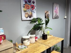 Une table en bois avec des ustensiles de cuisine, une plante en pot et des Ćuvres dâart murales.