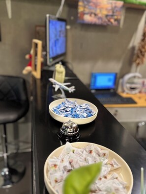Ein Empfangsbereich mit einer Snackschale, einem dekorativen Gegenstand und einem Laptop im Hintergrund.