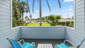 A covered outdoor seating area with a view of palm trees and a parking lot. - Salt & Sun - Beach & Pool (St. Augustine)
