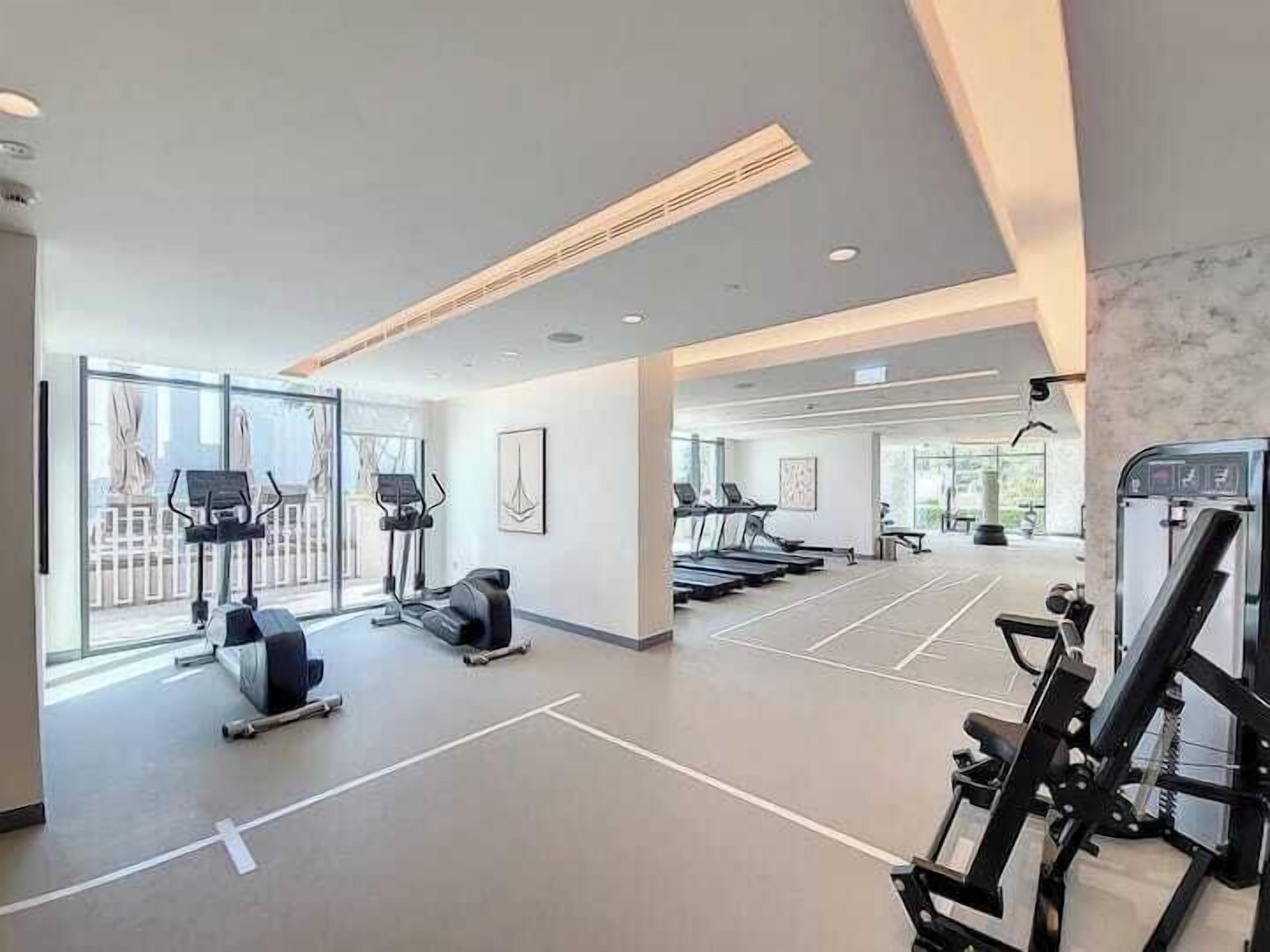 A gym with treadmills, elliptical machines, and weight equipment.