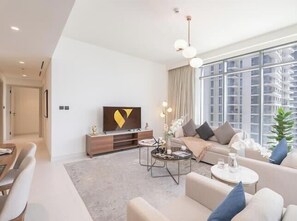 Luxury Apartment, Beach View | Living area | 65-inch Smart TV with satellite channels - Vogue | Emaar Beachfront Marina Vista with Private Beach Access (Dubai)