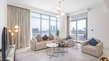 Departamento de lujo, vista a la playa | Área de sala de estar | Smart TV de 65 pulgadas con canales vía satélite