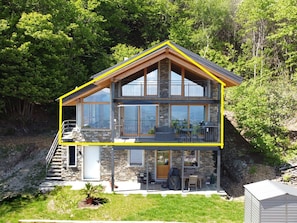 A two-story house with a stone facade, large windows, and a balcony. - Rustico Milu’ (Viggiona)