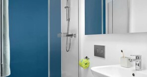 A bathroom with a white sink, a mirror, and a shower. - Student Only Scape Leeds (Leeds)