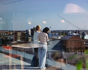 Two people standing on a balcony overlooking a cityscape. - Student Only Scape Leeds (Leeds)