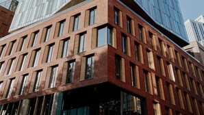 Ein modernes Gebäude mit Glasfassade und Backsteingrundmauer.