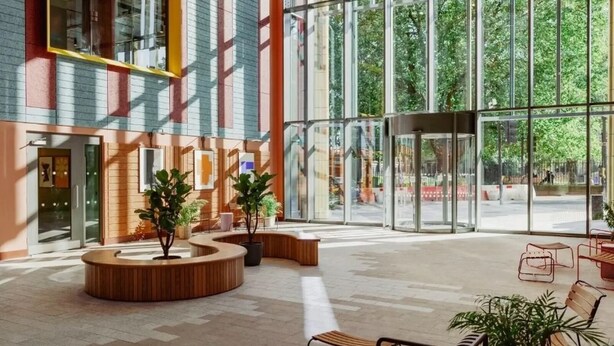 Eine geräumige Lobby mit großen Fenstern, einer gebogenen Sitzecke und einem modernen architektonischen Design.