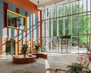 A spacious lobby with large windows, a curved seating area, and a modern architectural design. - Student Only Scape Leeds (Leeds)