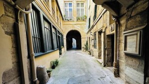 A narrow alleyway with stone walls and a central archway leading to a building. - Paris Marais by Melvane (Paris)