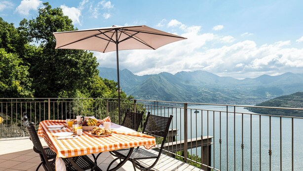 Un espace de restauration en plein air avec une table et des chaises, une nappe et un parasol.