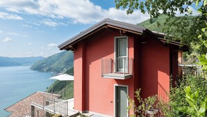 Un bâtiment rouge doté d’un balcon, d’une porte et d’une fenêtre.