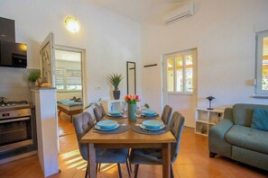 A compact living space with a dining area, kitchenette, and a sofa. - Casa Oliva Kim Marie (Medulin)