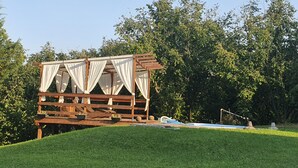A wooden gazebo with a canopy, surrounded by a well-maintained lawn and dense trees. - In the capital of the Langhe cottage with pool and garden (Ricca)