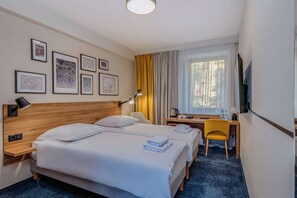 A hotel room with two beds, a desk, a chair, a TV, and framed maps on the wall. - Tulip Hotels - Wroclaw Centre (Wroclaw)