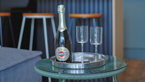 Een martini-fles en twee glaasjes op een dienblad op een tafel.