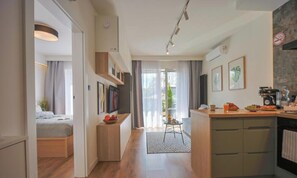 A modern kitchen with a dining area, a small table, and a view of the outdoors.