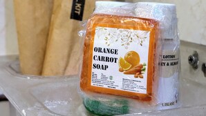 Une salle de bain avec un lavabo, un miroir et, au fond, deux sacs en papier marron étiquetés « Trousse de soins dentaires ».