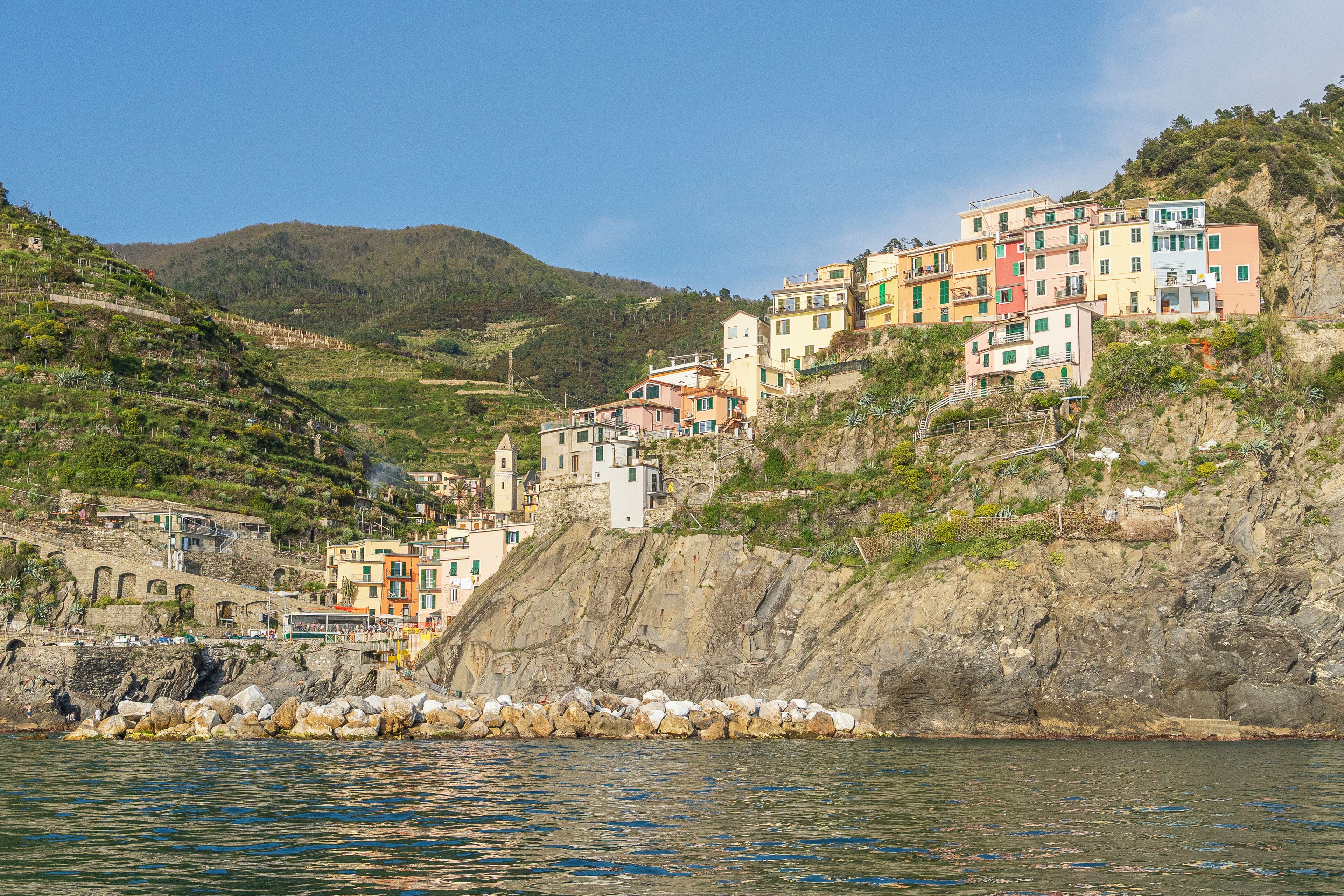 A coastal village with colorful buildings perched on a hillside overlooking the sea.