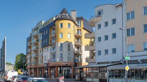 En byggnad med flera våningar, balkonger, ett kafé och en butik med ett skyltfönster.