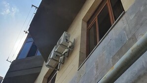 Un edificio de varios pisos con techo plano, ventanas amplias y unidades de aire acondicionado externas.