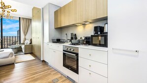 Une cuisine moderne avec des meubles blancs, un four encastré et un four à micro-ondes.