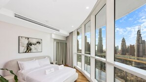Una camera d'albergo moderna con un letto grande, vista sulla città e un'arredamento minimalista.