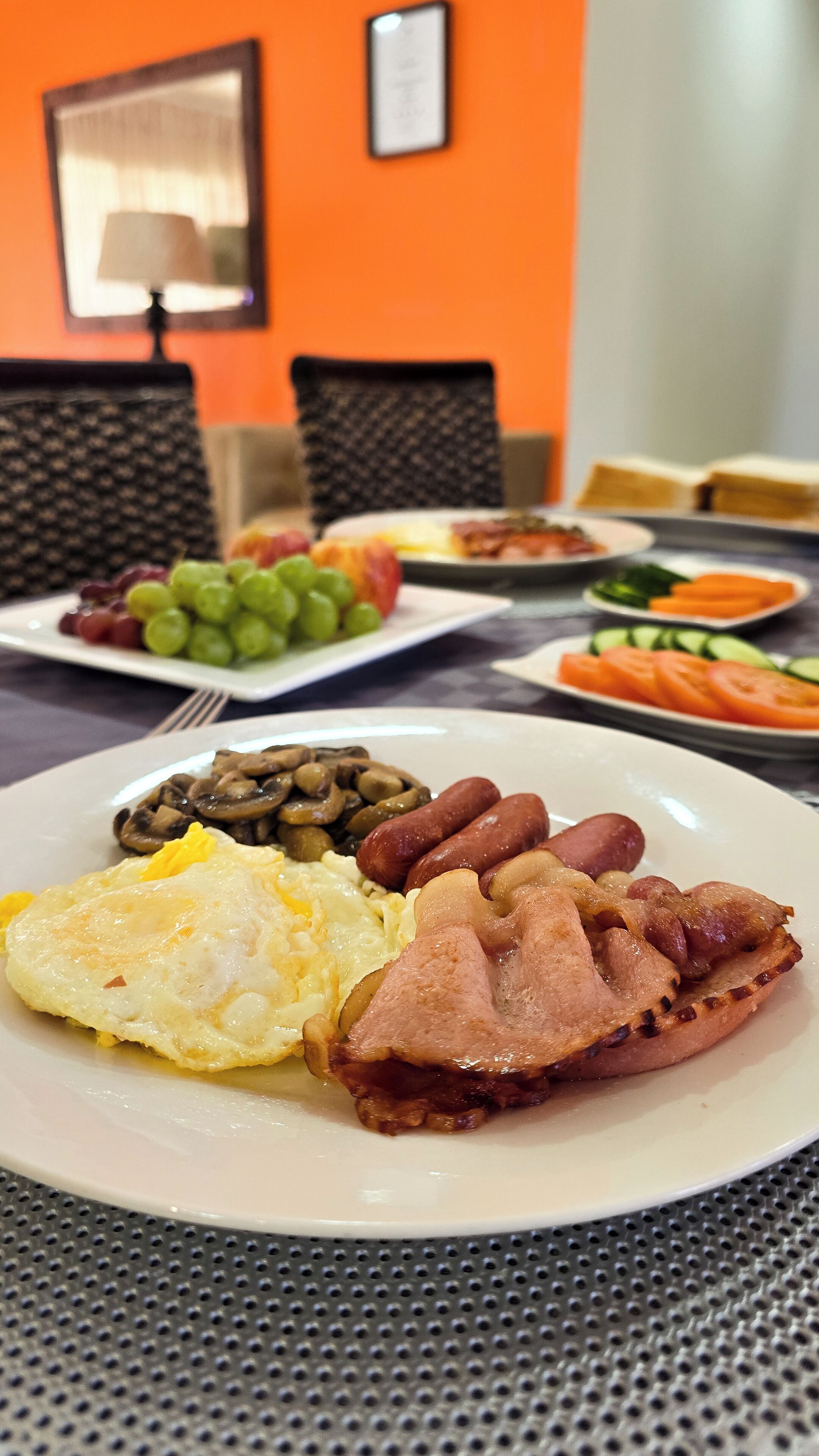 A breakfast plate with eggs, sausages, and mushrooms.